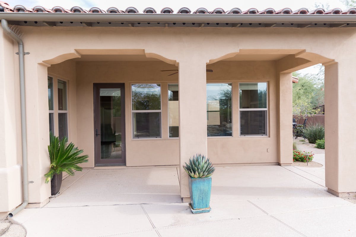 the exterior of the tuscun-style home before remodel