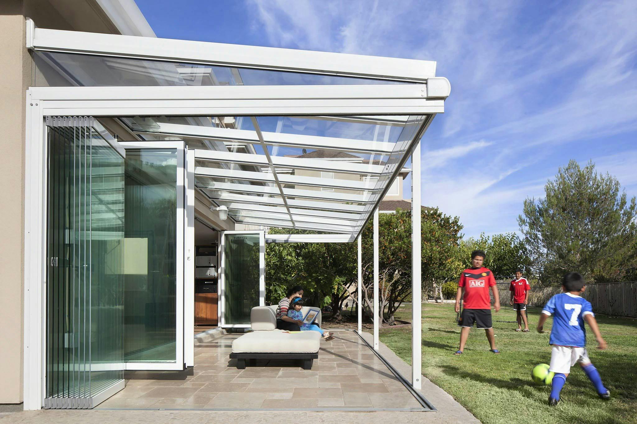 kids playing while bringing the outdoors in with opening glass walls