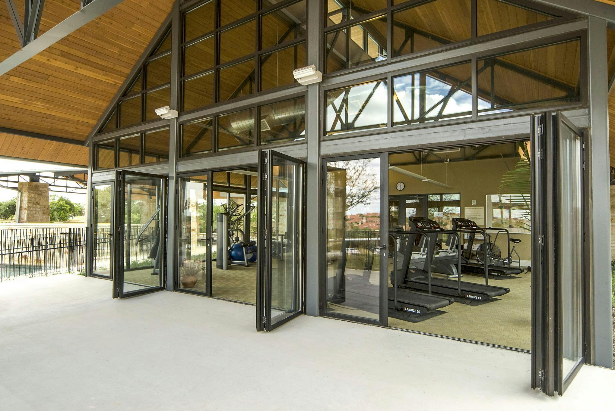 exercise room in multifamily complex with opening glass walls