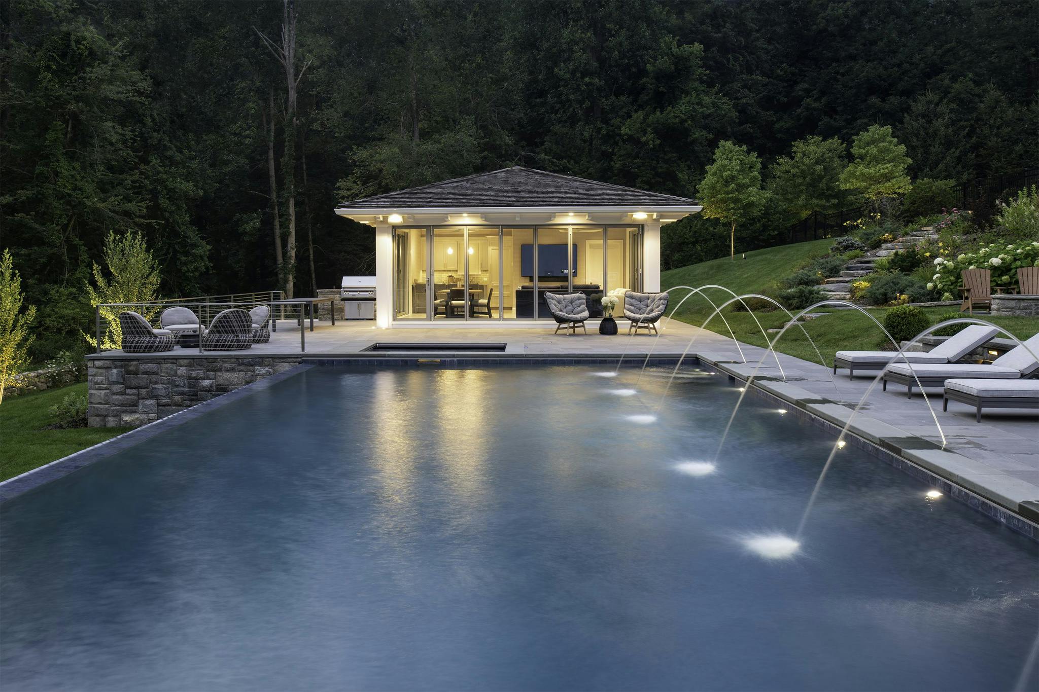 pool house with folding glass walls in nightime