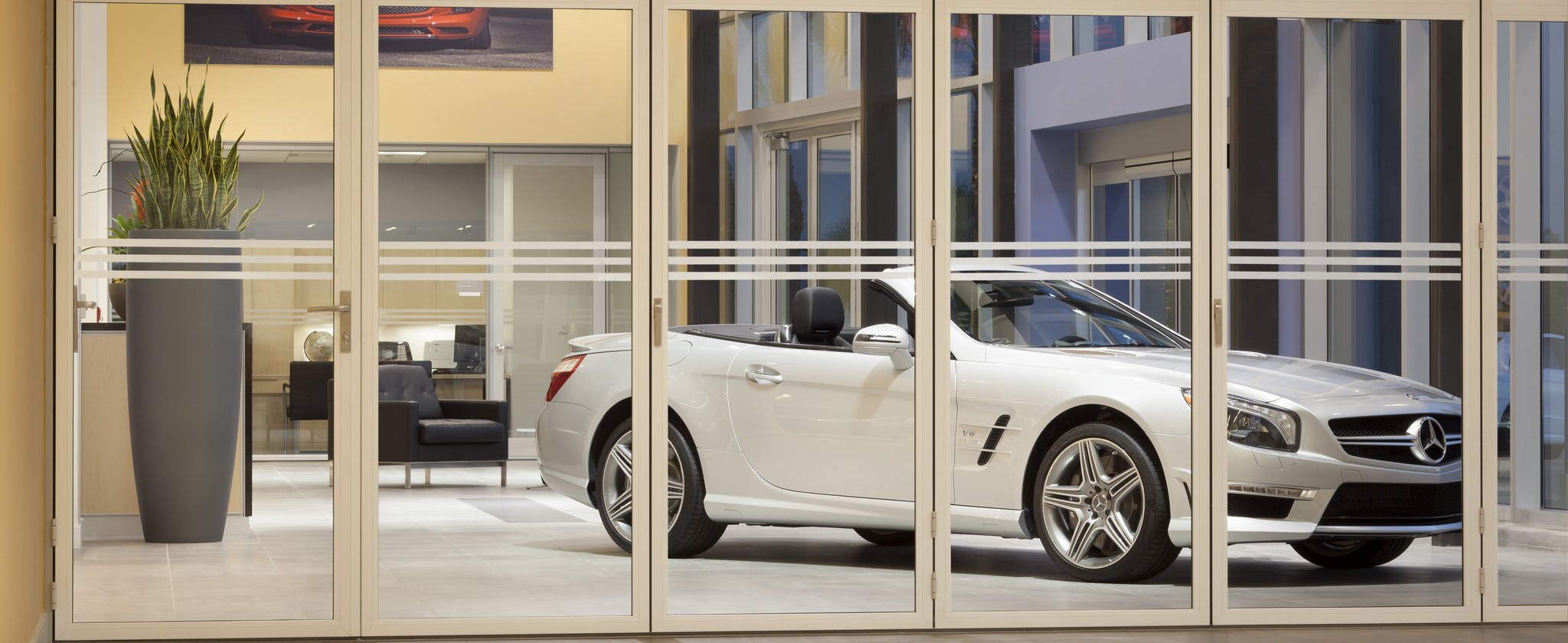 white convertible car parked in front of folding interior moveable glass doors